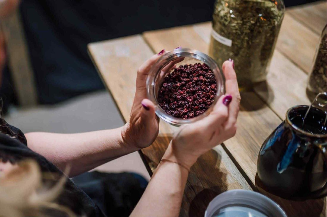 A photo of Angie's hands holding a jar of hibiscus tea cupped around the jar sides to show how Intuitive Herbalism is more about connecting with plants